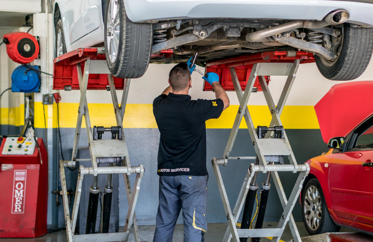 Mecànic de Rodi Motor Services treballant sota un cotxe al taller