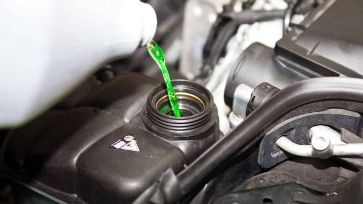 Mecànic de Rodi reemplenant el líquid refrigerant del cotxe